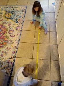 kids measuring leaps with tape measure
